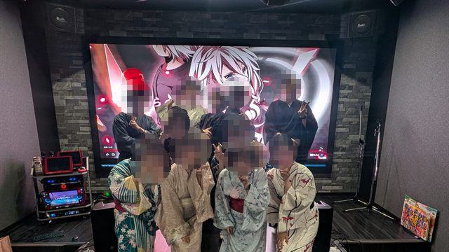 浴衣を着た参加者たちがステージのある部屋で並んだ集合写真